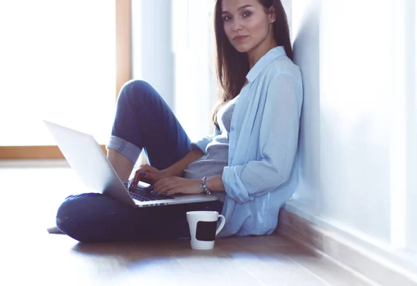 Mooie jongedame thuis zittend op de vloer met laptop. Mooie jongedame. — Stockfoto