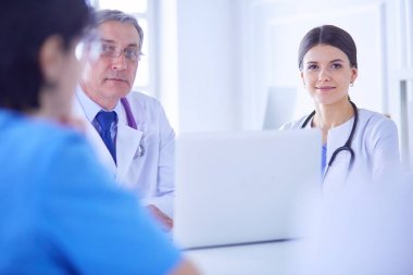 Parlak bir ofiste çalışan ciddi bir tıbbi ekip.