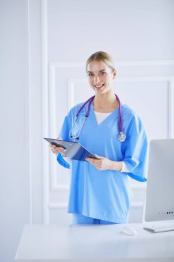 Üniformalı bir dosyayla gülümseyen kadın doktor