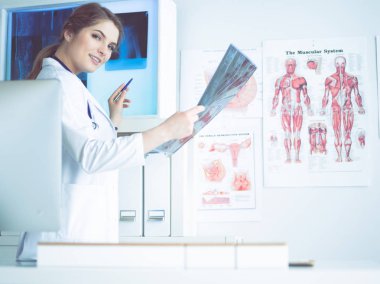 Genç, profesyonel kadın doktor hastaların röntgenlerini çekiyor.