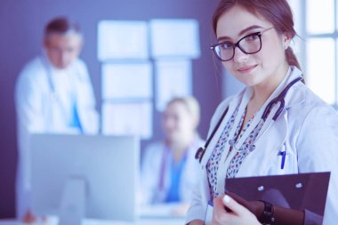 Kadın doktor hastanede steteskopla dikiliyor.