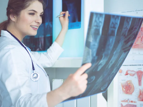 Fiatal női orvos nézi a röntgen képet a tüdő a kórházban — Stock Fotó