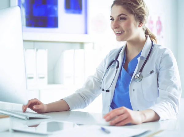 Giovane dottoressa seduta ad una scrivania e che lavora al computer dell'ufficio dell'ospedale. Assistenza sanitaria, assicurazione e concetto di aiuto. Medico pronto ad esaminare il paziente — Foto Stock