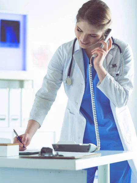 Serious doctor on the phone in her office — Stock Photo, Image