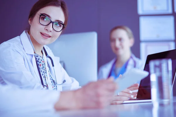 Serious medical team using a laptop in a bright office — Stock Photo, Image