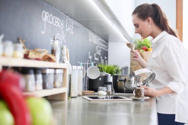 Genç kadın tableti mutfakta..