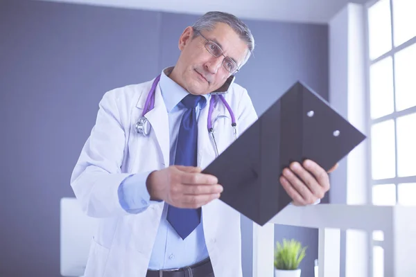 Male doctor writes notes on the clipboard in the hospital