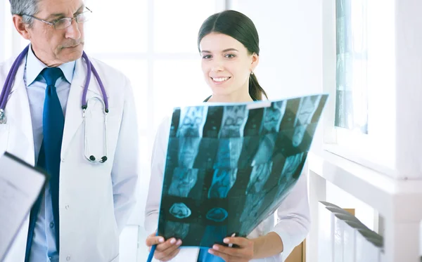 Usmívající se lékaři diskutující o diagnóze pacientů při pohledu na rentgeny v nemocnici — Stock fotografie