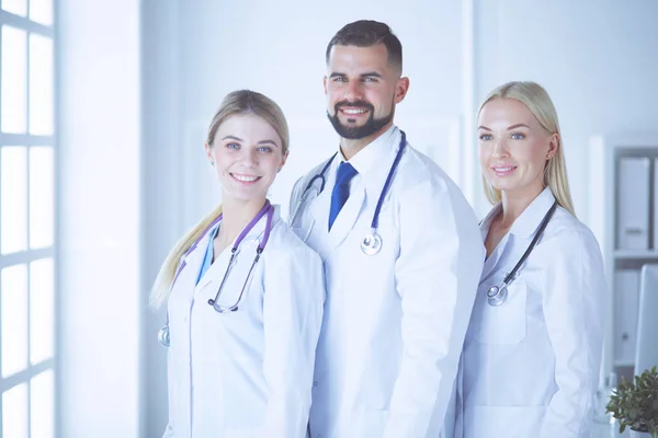 Οι χαμογελαστοί γιατροί στέκονται μαζί σε μια αίθουσα συμβούλων. — Φωτογραφία Αρχείου