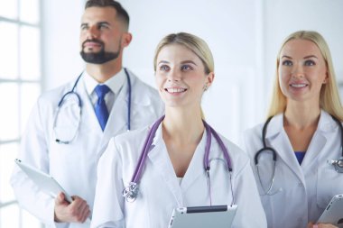 Gülümseyen doktorlar çalışırken bir arada duruyorlar.