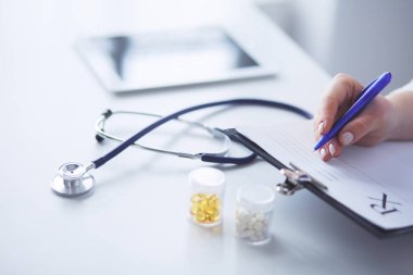 Steteskop cam masanın üzerinde duruyor. Yoğun bir doktor geçmişinde dizüstü bilgisayarı var. İlaç ya da eczane konsepti. Doktor çalışma masasında tıbbi aletler