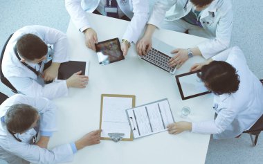 Tıbbi ekip masaya oturuyor ve tartışıyor.