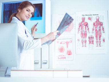 Genç, profesyonel kadın doktor hastaların röntgenlerini çekiyor.