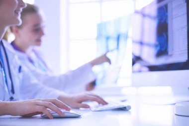 Hastanede bilgisayarla çalışan iki genç bayan doktor..