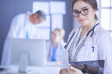 Kadın doktor hastanede steteskopla dikiliyor.