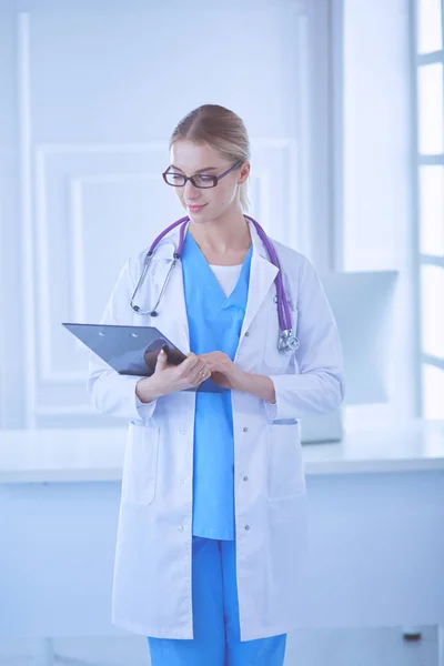 Smiling female doctor with a folder in uniform standing — Stock Photo, Image