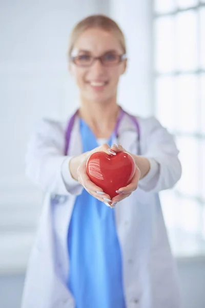 彼女の腕に心臓を保持する聴診器を持つ女性医師。医療におけるヘルスケアと心臓病の概念 — ストック写真