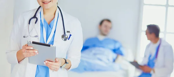 Female doctor using tablet computer in hospital lobby