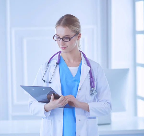 Smiling female doctor with a folder in uniform standing — Stock Photo, Image