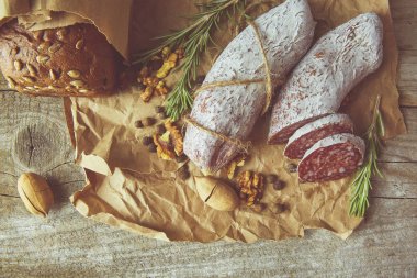 İtalyan salamı, deniz tuzu, biberiye, sarımsak ve fındık. Kırsal tarzda. Üst görünüm.