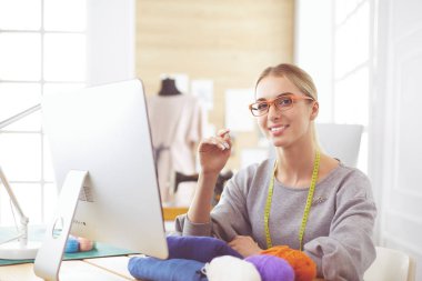 Moda tasarımcısı stüdyoda tablet bilgisayar kullanıyor.