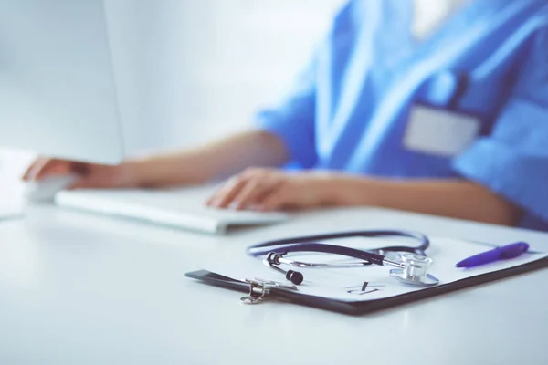 Vrouwelijke arts zit en werkt een laptop — Stockfoto