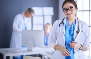 Hastane lobisinde tablet bilgisayar kullanan kadın doktor.
