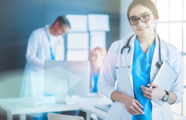 Hastane lobisinde tablet bilgisayar kullanan kadın doktor.
