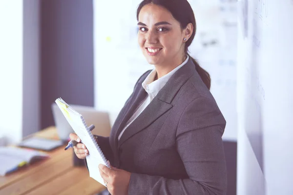 Business, formazione e concetto di ufficio - team di lavoro con flip board in ufficio discutendo di qualcosa. — Foto Stock