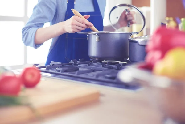 Wanita memasak di dapur dengan sendok kayu — Stok Foto