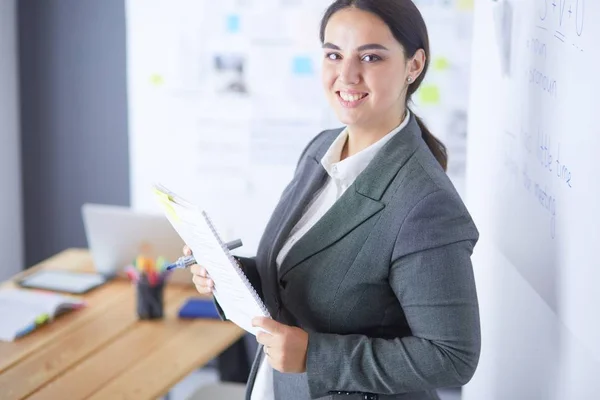 Business, formazione e concetto di ufficio - team di lavoro con flip board in ufficio discutendo di qualcosa. — Foto Stock