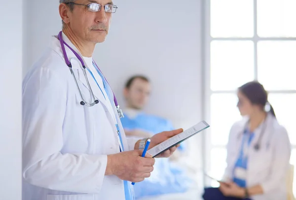 Médecin tenant un dossier devant un patient et un médecin — Photo