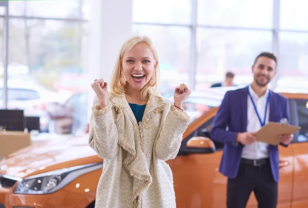 年轻漂亮的女人买了一辆新车后很开心 — 图库照片