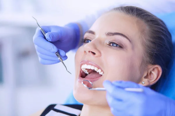 Mujer joven con la boca abierta examinando la inspección dental en el consultorio del dentista. — Foto de Stock