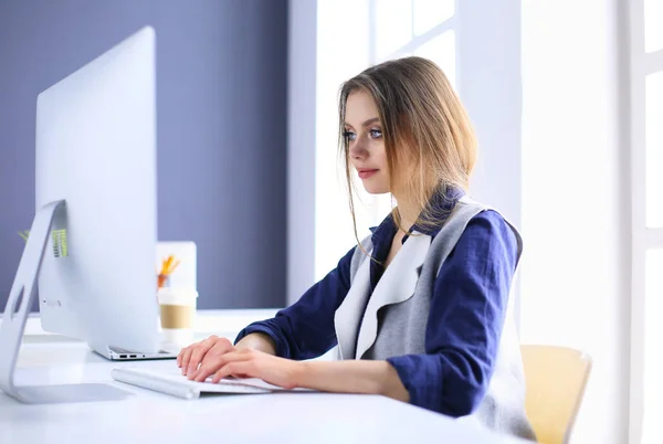 Jovem empresária confiante trabalhando na mesa de escritório e digitando com um laptop — Fotografia de Stock