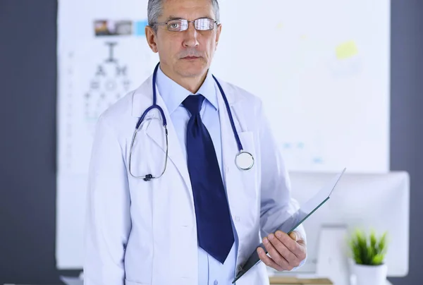 Homme médecin écrit des notes sur le presse-papiers à l'hôpital — Photo