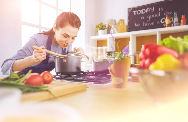 Kochende Frau in Küche mit Kochlöffel — Stockfoto