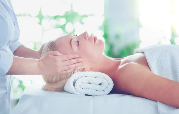 Schöne junge Frau entspannt sich bei einer Ganzkörpermassage im Wellnessbereich — Stockfoto