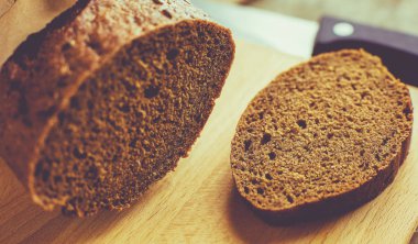 Tahta masanın üzerinde kağıda sarılı bir somun ekmek..