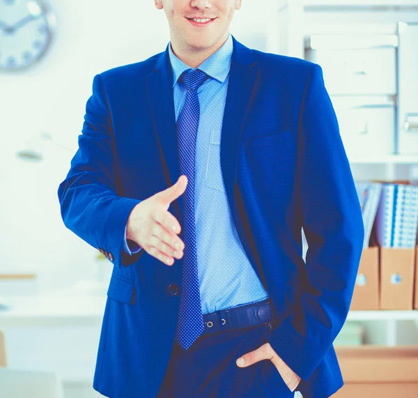 Udany biznes człowiek stojący w biurze dając rękę — Zdjęcie stockowe