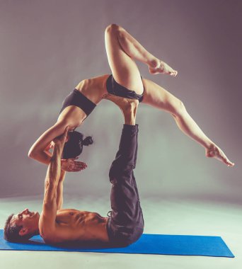 Genç çift Acro yoga mat Studio birlikte uygulamak. Acroyoga. Çift yoga. Ortak yoga.