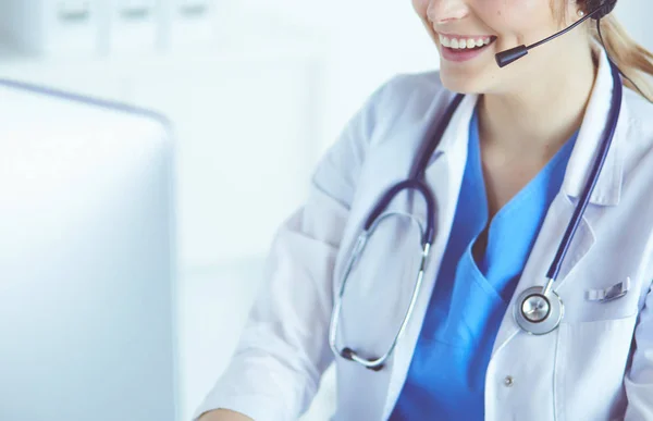 Doctor wearing headset sitting behind a desk with laptop — Stock Photo, Image