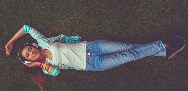 Krásná mladá žena ležící na zelené trávě — Stock fotografie