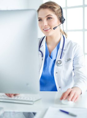 Kliniği Resepsiyon masasında çalışan genç pratisyen doktor o telefon görüþmesi ve randevuları zamanlama