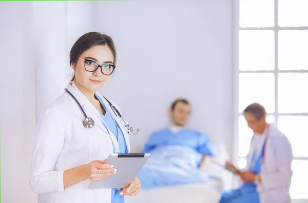 Médico femenino usando tableta en el vestíbulo del hospital —  Fotos de Stock