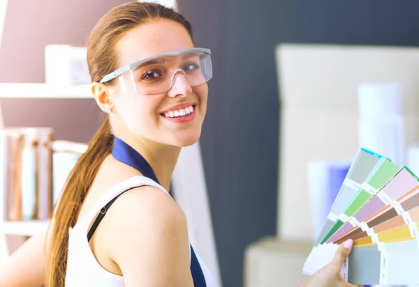 Jovem segurando uma amostra de cor com uma pintura de pintor  . — Fotografia de Stock