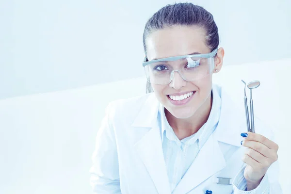 Vacker kvinnlig tandläkare håller och visar en tandborste isolerad på en vit bakgrund. Tandläkare — Stockfoto