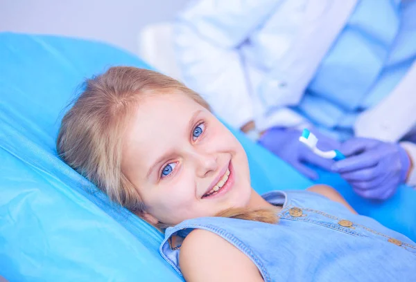 Mała dziewczynka siedzi w gabinecie dentystycznym. — Zdjęcie stockowe