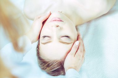 Masaj masasında uzanmış gözleri kapalı rahatlayan genç bir kadın. - Kadın. Spa salonu