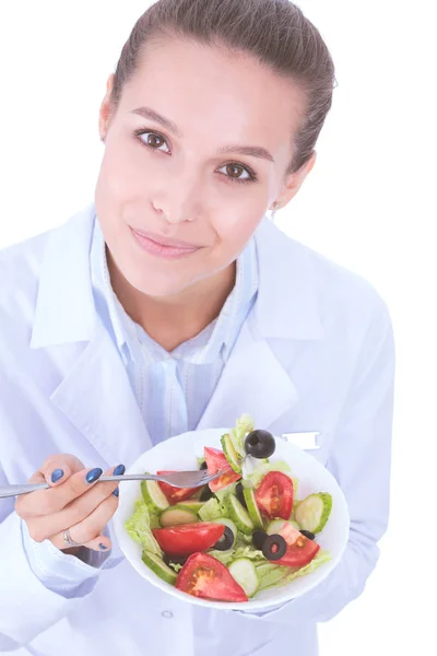 Porträtt av en vacker kvinnlig läkare som håller en tallrik med färska grönsaker. Kvinnliga läkare. — Stockfoto